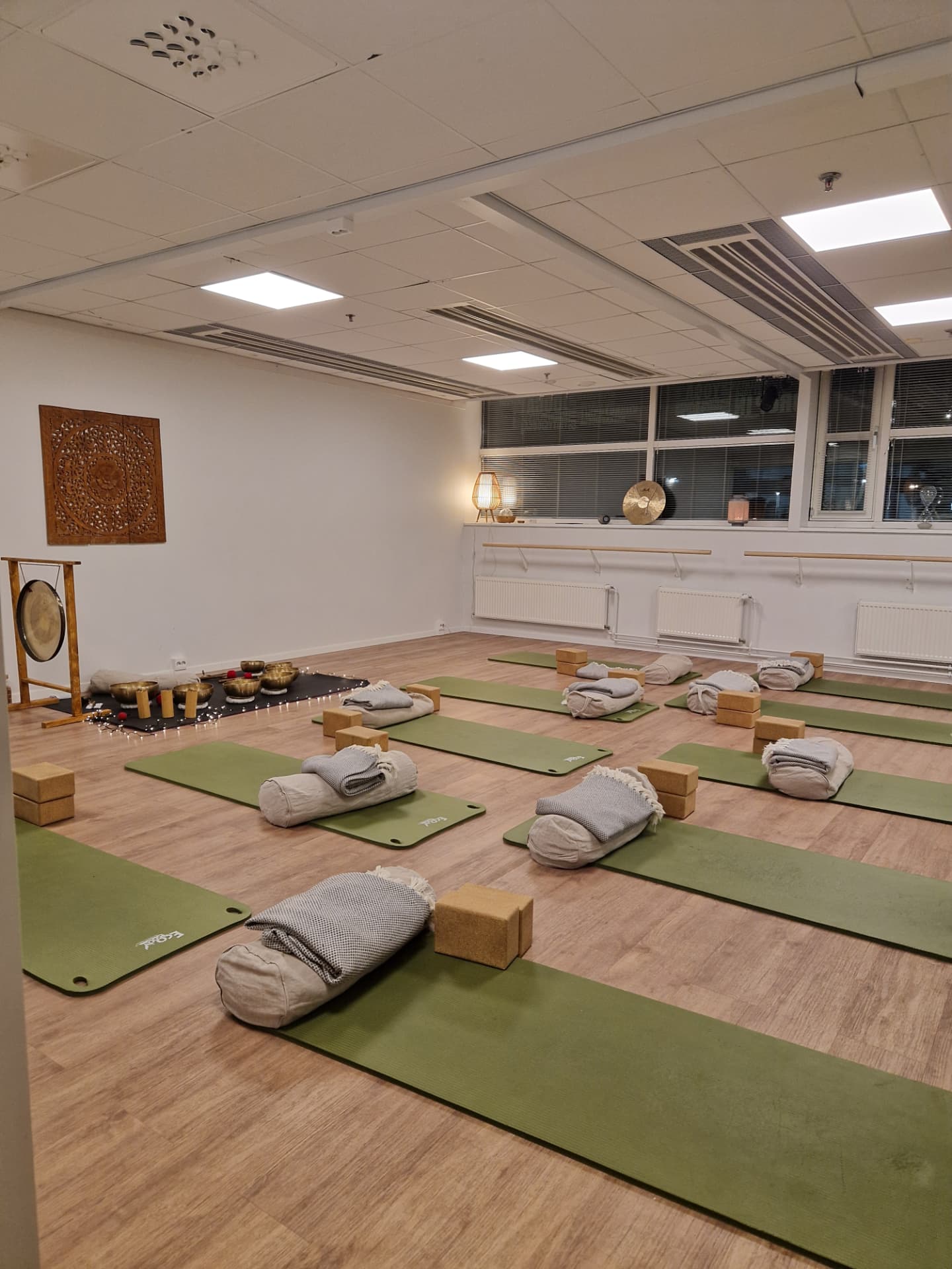 A studio prepared for an evening private event with mats, bolsters and candles