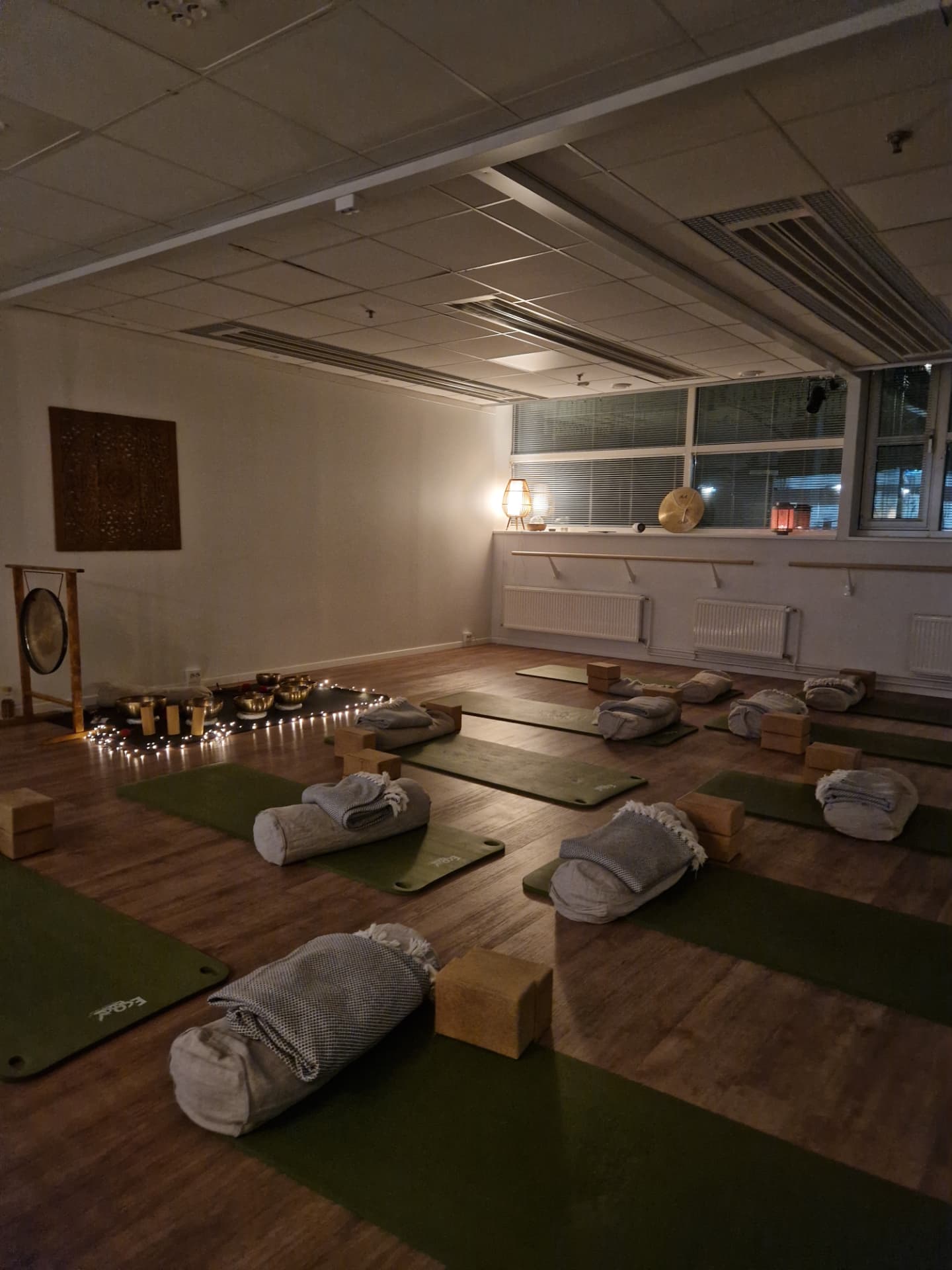 A candlelit studio set up for a private sound bath gathering