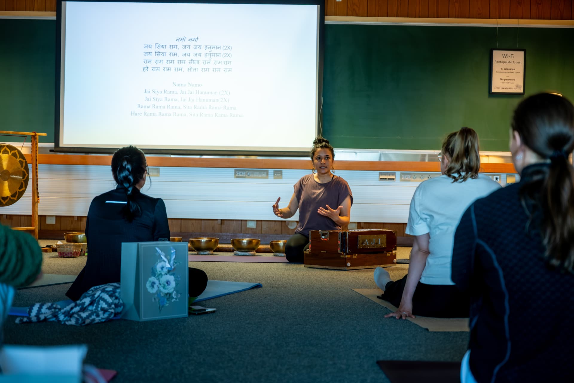 Uma leading a kirtan with harmonium and singing bowls