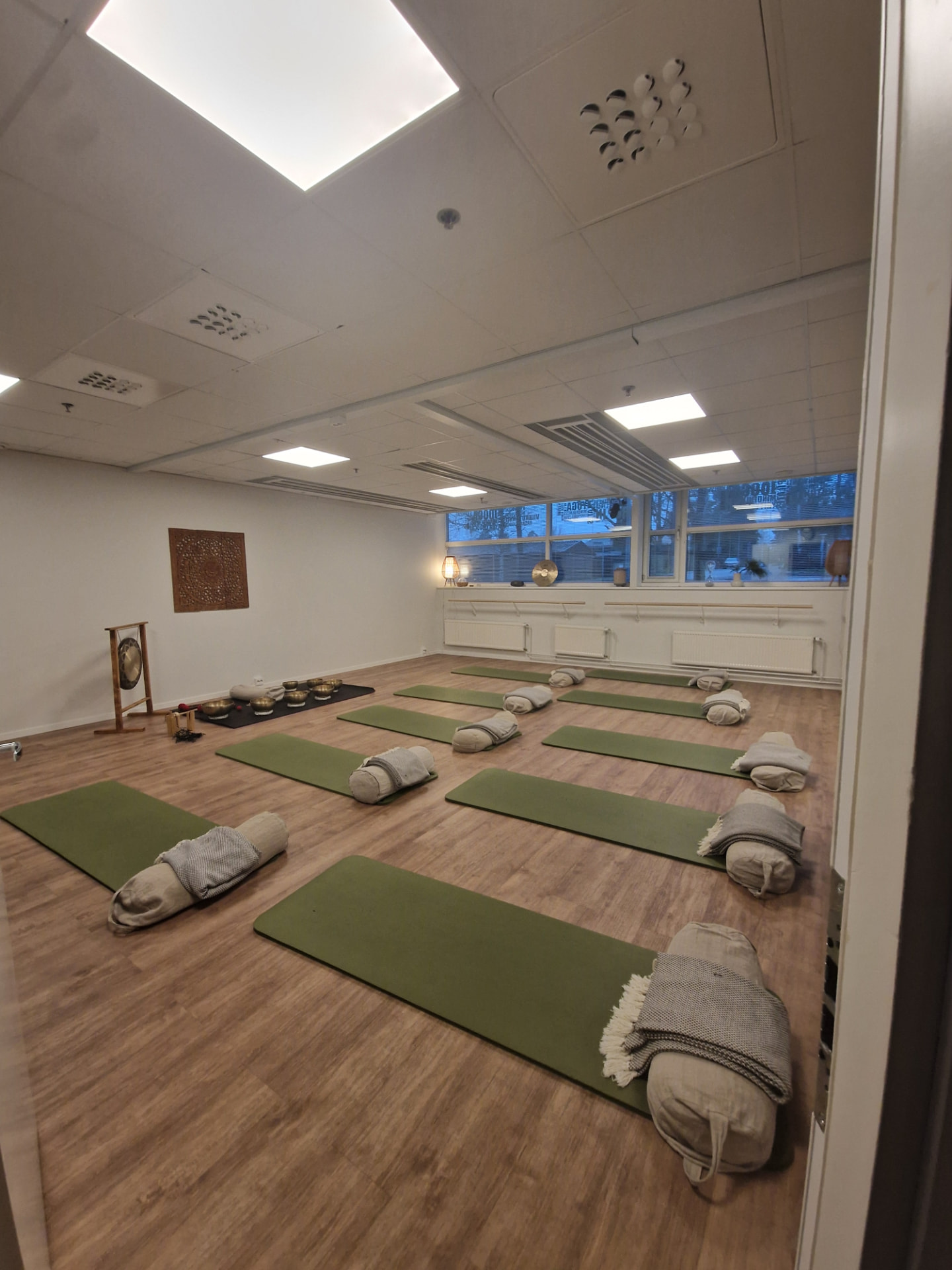 A retreat studio set up with yoga mats and bolsters in natural daylight